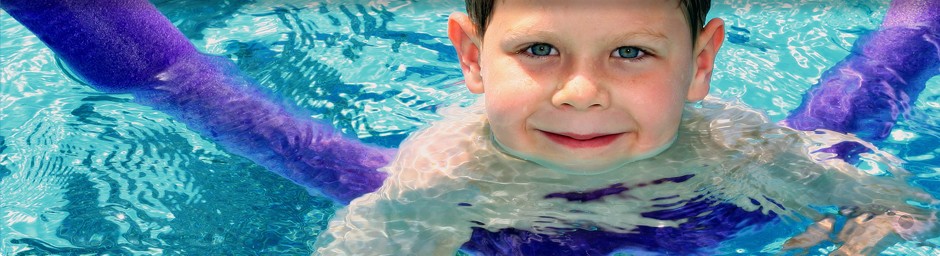 Un enfant souriant pendant son cours de natation